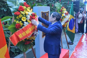Thủ tướng Chính phủ Phạm Minh Chính chỉnh hoa chuẩn bị thực hiện nghi thức dâng hoa tưởng niệm Chủ tịch Hồ Chí Minh tại Rio de Janeiro (Ảnh: Thanh Giang).