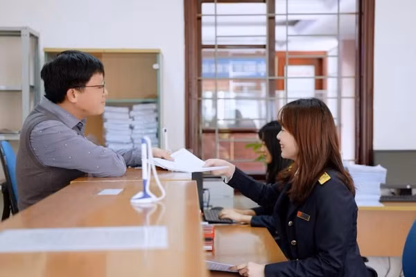 Công chức thuế hướng dẫn người dân làm thủ tục thuế. (Ảnh: Kỳ Duyên)