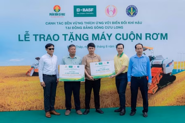 Đại diện các hợp tác xã nhận máy cuộn rơm từ chương trình. (Ảnh: Đạm Cà Mau)