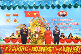 Đồng chí Hồ Thanh Sơn (phải) tặng lẵng hoa chúc mừng Đại hội.