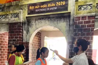Đo thân nhiệt cho khách tham quan tại di tích Hoàng thành Thăng Long.