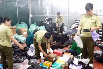 Lực lượng chức năng tiến hành kiểm đếm, phân loại, đóng gói hàng hóa tại kho hàng lậu ở số 145, đường Hoàng Diệu, TP Lào Cai.