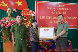 Gia đình Liệt sĩ Trần Văn Dũng (vợ và con trai bên trái) nhận Bằng “Tổ quốc ghi công”.
