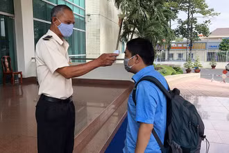 Đo thân nhiệt cho khách đến liên hệ tại một công sở ở Đồng Nai.
