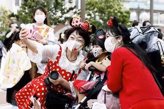 Du khách tới Công viên giải trí Disneyland Tokyo phải đeo khẩu trang bắt buộc (Ảnh: CNN)