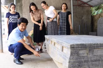 Cán bộ Bảo tàng Ninh Bình nghiên cứu họa tiết, hoa văn trên sập đá cổ, phát hiện ở xã Xích Thổ, huyện Nho Quan (Ninh Bình).