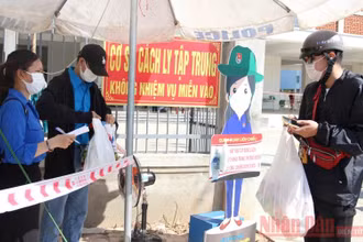 Tường Vỹ (bìa trái) ghi thông tin tiếp nhận đồ cho người cách ly.