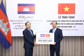 Thứ trưởng Ngoại giao Nguyễn Quốc Dũng trao tượng trưng cho Đại sứ Campuchia tại Việt Nam Chay Navuth khoản hỗ trợ 200.000 USD. (Ảnh: Bộ Ngoại giao Việt Nam)
