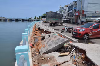 Một vị trí bị sụt lún, tạo thành hố sâu hơn 1m, dài hơn 10m có nguy cơ làm sụp bờ kè xuống sông bất cứ lúc nào.