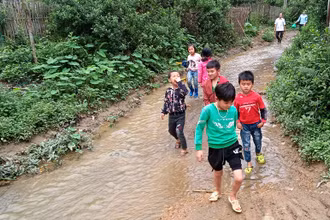 Con em xóm Tân Kim thường xuyên phải đi dọc dưới dòng suối ô nhiễm.
