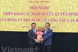 Bí thư Trung ương Đảng, Trưởng Ban Tuyên giáo Trung ương Nguyễn Trọng Nghĩa tặng hoa và chúc mừng tân Bộ trưởng Bộ Công thương Nguyễn Hồng Diên. (Ảnh: Vietnam+)