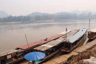 Tàu, thuyền trên sông Mê Kông tại Lào hiện bị ngưng hoạt động hoặc đưa lên bờ nhằm ngăn chặn việc đưa người vượt biên trái phép.