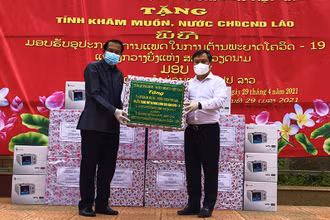 Bí thư Tỉnh ủy Quảng Bình Vũ Đại Thắng (áo trắng) trao tặng thiết bị phòng chống dịch cho lãnh đạo tỉnh Khăm Muộn.
