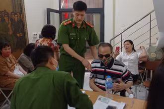 Đội Cảnh sát QLHC về TTXH Công an quận Ba Đình hỗ trợ ông Đinh Phương Thi là thương binh hỏng mắt, làm thủ tục cấp CCCD mới.