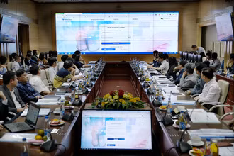 Các đại biểu nghe đơn vị phát triển một phần mềm giới thiệu về hệ thống đặt lịch khám, chữa bệnh trực tuyến.