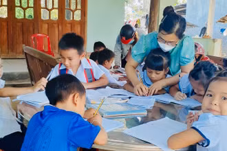 Cô giáo Trường tiểu học Thanh An hướng dẫn học sinh tại các điểm trường trong thôn. 