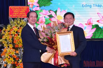 Bộ trưởng Nguyễn Kim Sơn trao Quyết định và tặng hoa chúc mừng tân Hiệu trưởng Trường Đại học Đồng Tháp Hồ Văn Thống.