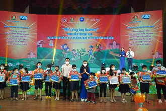Đồng chí Nguyễn Phạm Duy Trang (áo xanh) và đại diện các đơn vị liên quan trao bảo trợ dài hạn tặng thiếu nhi mồ côi do đại dịch Covid-19.