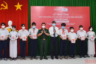 Ông Nguyễn Lưu Trung, Phó Chủ tịch UBND tỉnh Kiên Giang (thứ 5 từ phải sang) trao tặng máy tính bảng cho đại diện các em học sinh.