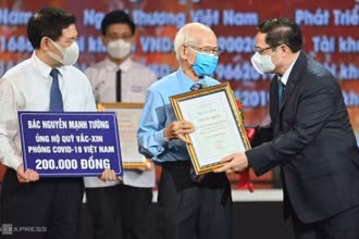 Thủ tướng Chính phủ Phạm Minh Chính trao chứng nhận, hoa cảm ơn bác Nguyễn Mạnh Tường 82 tuổi, cán bộ hưu trí ngành đường sắt đã đóng góp cho Quỹ vaccine phòng Covid-19.