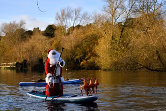 Hóa trang thành ông già Noel và dùng ván lướt sóng di chuyển trên sông Liffey, thành phố Dublin, Ireland, để mang đến niềm vui Giáng sinh trong không khí ảm đạm của đại dịch Covid-19.