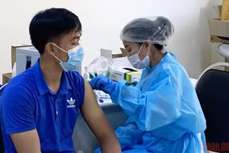 Tiêm vaccine ngừa Covid-19 mũi ba tại Bệnh viện Hữu nghị, nhằm chuẩn bị cho mở cửa quốc gia của Lào. (Ảnh: Xuân Sơn)