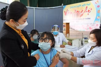 Giáo viên Trường THPT Quảng Xương 1 động viên học sinh tiêm chủng phòng Covid-19. (Ảnh: MAI LUẬN)