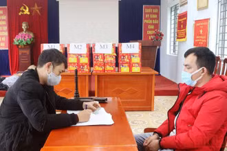Đối tượng Phạm Văn Tiệp (áo đỏ) và tang vật tại cơ quan công an.
