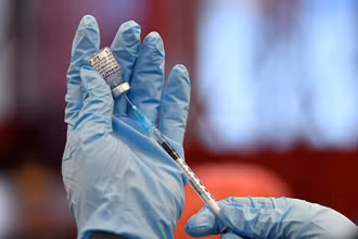 Chuẩn bị tiêm một liều vaccine ngừa Covid-19 của Pfizer. Ảnh: Reuters.