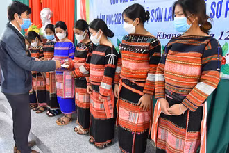 Tặng thẻ bảo hiểm y tế cho học sinh người dân tộc thiểu số có hoàn cảnh khó khăn. (Ảnh: Bảo hiểm xã hội Gia Lai)