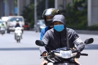 Người dân Hà Nội mặc kín mít khi phải di chuyển trên đường giữa trời nắng nóng. (Ảnh: Hoàng Hiếu/TTXVN) 