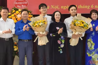 Đồng chí Trương Thị Mai tặng hoa hai đảng viên trẻ tại Trường THPT chuyên Hà Nội-Amsterdam. (Ảnh: SƠN BÁCH)