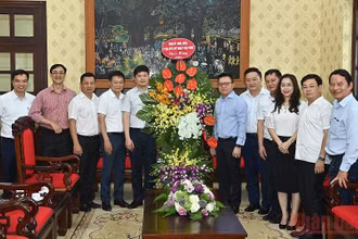 Tổng Biên tập Lê Quốc Minh cùng lãnh đạo Báo Nhân Dân đón nhận lẵng hoa chúc mừng của đoàn đại biểu Thành ủy, HĐND, UBND, Ủy ban MTTQ Việt Nam TP Hải Phòng. (Ảnh: DUY LINH)