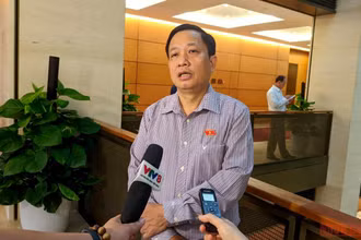 Đại biểu Hà Quốc Trị trao đổi bên hành lang Quốc hội. (Ảnh: TRUNG HƯNG)