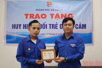 Trao Huy hiệu “Tuổi trẻ dũng cảm” cho anh Phan Thanh Phú.