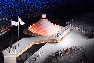 Quốc kỳ Nhật Bản (phải) và cờ Olympic tại lễ khai mạc Olympic Tokyo 2020 ở Tokyo, Nhật Bản, ngày 23/7/2021. (Ảnh: TTXVN)