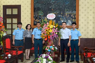 Đoàn đại biểu Bộ Tư lệnh Quân chủng Phòng không-Không quân tặng hoa chúc mừng Báo Nhân Dân. (Ảnh: DUY LINH)
