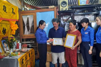 Quyền Bí thư Tỉnh đoàn Vĩnh Long Nguyễn Thụy Yến Phương trao Huy hiệu “Tuổi trẻ dũng cảm” cho gia đình em Nguyễn Minh Quân.