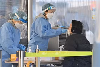 Nhân viên y tế lấy mẫu xét nghiệm Covid-19 cho người dân tại Seoul, Hàn Quốc. (Ảnh: AFP/TTXVN)