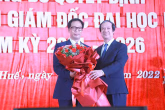 Bộ trưởng Giáo dục và Đào tạo Nguyễn Kim Sơn trao Quyết định, tặng hoa chúc mừng Giám đốc Đại học Huế Lê Anh Phương (bên trái ảnh).
