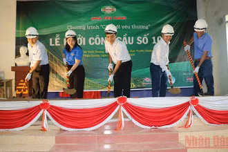 Các đại biểu và nhà tài trợ thực hiện động tác khởi công xây dựng cầu.