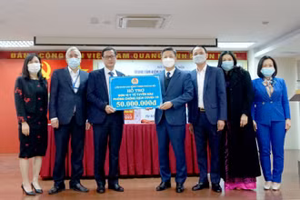 Lãnh đạo Liên đoàn Lao động thành phố Hà Nội tặng quà Trung tâm kiểm soát bệnh tật thành phố. (Ảnh: LĐ)