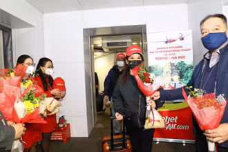 Lãnh đạo Cục Hàng không tặng hoa cho hành khách trên chuyến bay. (Ảnh: Hãng hàng không Vietjet cung cấp)
