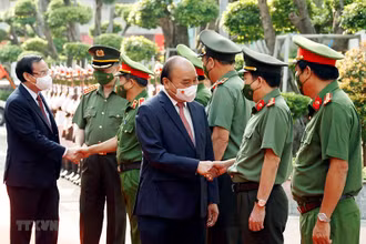 Chủ tịch nước Nguyễn Xuân Phúc, Bộ trưởng Công an Tô Lâm và Bí thư Thành ủy Thành phố Hồ Chí Minh Nguyễn Văn Nên với các lãnh đạo Công an Thành phố Hồ Chí Minh. (Ảnh: Thống Nhất/TTXVN)