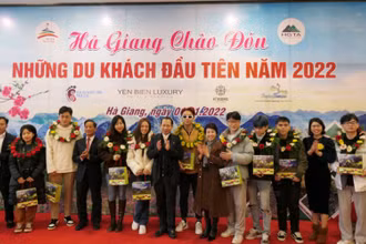 Lãnh đạo tỉnh Hà Giang tặng hoa và quà chúc mừng những vị khách đầu tiên.