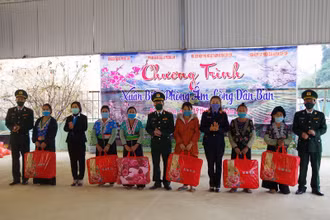 Đại diện Đảng ủy Bộ Chỉ huy Bộ đội Biên phòng tỉnh và lãnh đạo xã Mường Lạn tặng quà Tết cho các hộ gia đình nghèo bản Pu Hao.