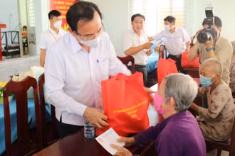Đồng chí Nguyễn Văn Nên, Ủy viên Bộ Chính trị, Bí thư Thành ủy TP Hồ Chí Minh (bên trái) trao quà tặng người dân.
