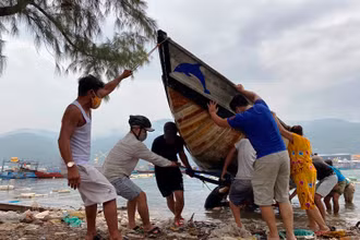 Lực lượng chức năng giúp người dân kéo tàu thuyền vào bờ, tránh bão số 5, sáng ngày 17-9.