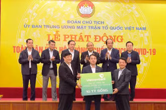 Đồng chí Nghiêm Xuân Thành - Chủ tịch HĐQT Vietcombank (giữa) trao biển tượng trưng số tiền ủng hộ công tác phòng, chống dịch Covid-19 của Vietcombank tại Lễ phát động toàn dân ủng hộ phòng, chống dịch Covid-19 do Ủy ban Trung ương MTTQ Việt Nam phát động với sự chứng kiến của Thủ tướng Chính phủ và lãnh đạo các bộ, ban, ngành.