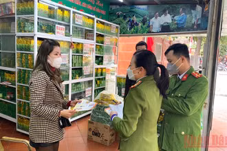 Cán bộ Đội cảnh sát phòng cháy, chữa cháy và cứu nạn cứu hộ (Công an quận Thanh Xuân, Thành phố Hà Nội) phát tờ rơi, tuyên truyền phòng chống cháy nổ tại một cửa hàng kinh doanh trà tại phường Thanh Xuân Bắc.